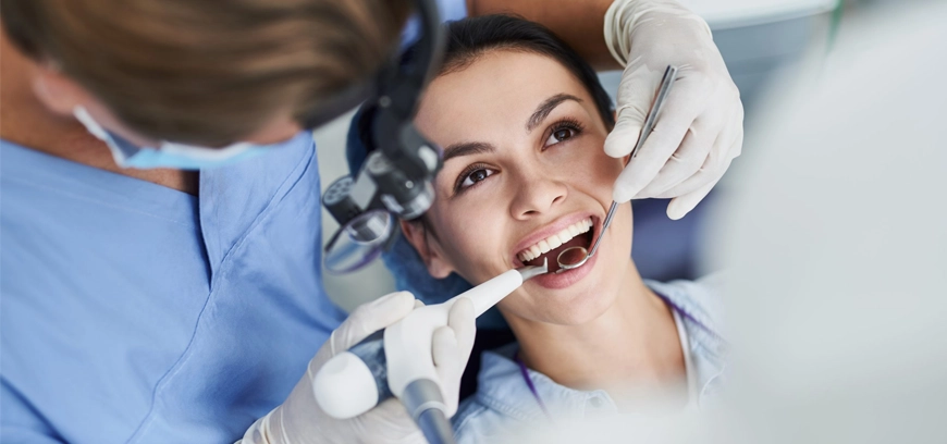 Dental treatment for a smiling woman using dental tools at a clinic in Peelamedu Coimbatore.